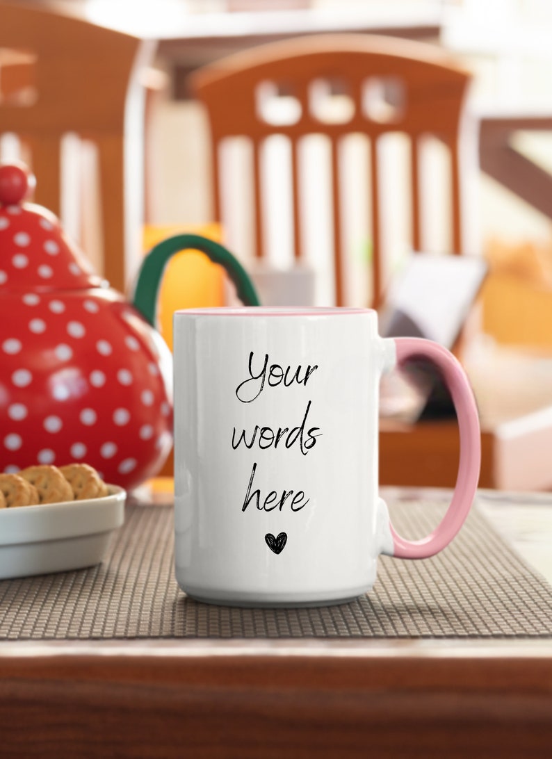 May include: White ceramic mug with a pink rim and handle. The mug has the text "Your words here" written in black cursive with a small heart below the text.