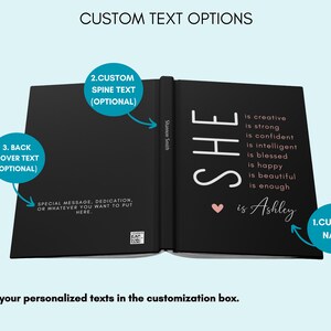May include: A black hardback journal with a white inscription that reads "SHE is creative is strong is confident is intelligent is blessed is happy is beautiful is enough &hearts; is Ashley". The spine of the journal has the text "Shannon Smith" printed on it. The journal is open to reveal the inside pages. The journal has space for a custom name, spine text, and back cover text.
