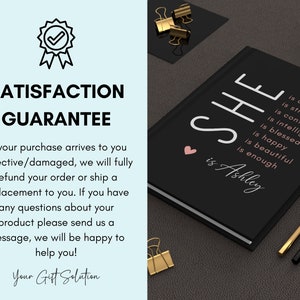 May include: Black journal with the text "SHE is Ashley" and a pink heart. The text also includes a list of positive attributes, such as "creative", "strong", "confident", "intelligent", "blessed", "happy", "beautiful", and "enough".