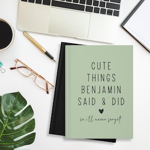 May include: A green journal with the text "Cute things Benjamin said & did so I'll never forget" in black text with a small heart symbol.