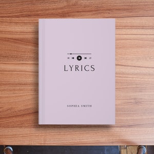 May include: A lavender-colored book with the title "LYRICS" in black text. The book has a black music player icon with play, rewind, and fast forward buttons. The author's name, "SOPHIA SMITH", is printed in black at the bottom of the cover.