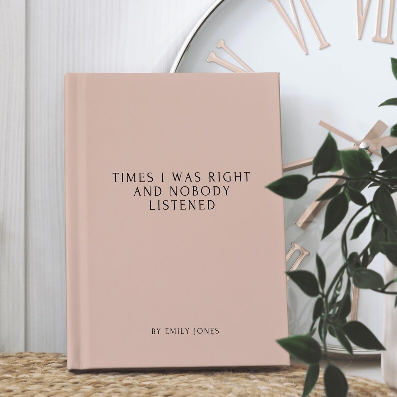 May include: A blush-colored book with the text "TIMES I WAS RIGHT AND NOBODY LISTENED" in black. The author's name, "BY EMILY JONES," is printed below. The book is set against a neutral background with a clock and greenery.