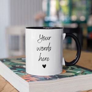 May include: White ceramic mug with a black rim and handle. The mug has the text "Your words here" and a small heart printed on it.