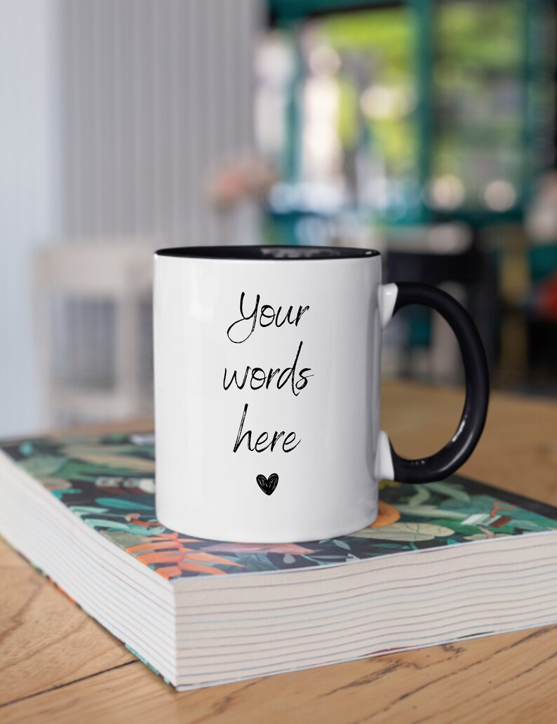 May include: White ceramic mug with a black rim and handle. The mug has the text "Your words here" and a small heart printed on it.