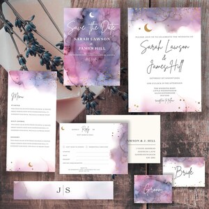 May include: A set of wedding invitations featuring a celestial theme. The invitations are printed on watercolour paper with a pink and purple background and gold glitter accents. The text on the invitations is in white and includes the names of the bride and groom, the date of the wedding, and the location of the ceremony. The invitations also include a menu card, RSVP card, and a map to the wedding venue.
