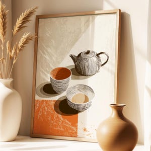 May include: A framed art print featuring a teapot and two bowls in a minimalist style. The artwork has a neutral color palette with orange and brown accents. The teapot and bowls are detailed with vertical lines.