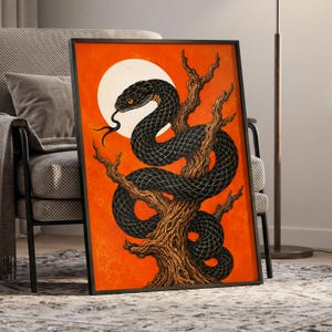 May include: A framed rectangular wall art print featuring a black snake coiled around a textured brown tree branch against a vibrant orange background with a large white circular moon behind the snake's head and a forked tongue visible.