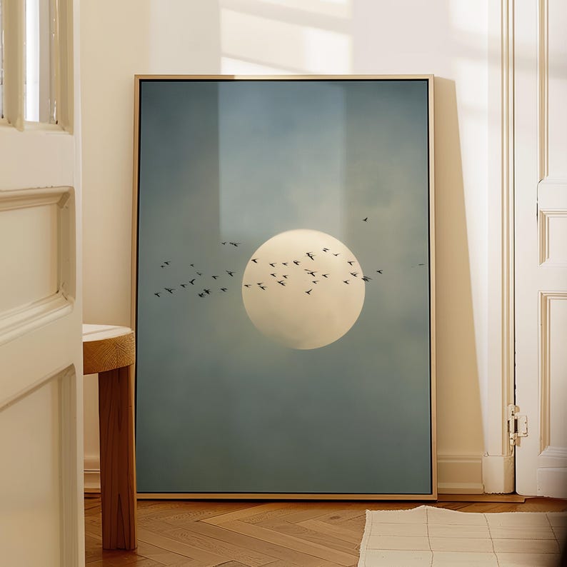 Pu&ograve; includere: Una stampa artistica incorniciata con un grande sole giallo pallido in un cielo blu, con uno stormo di uccelli in silhouette. L'opera d'arte &egrave; in una cornice dorata, creando una scena serena e naturale.