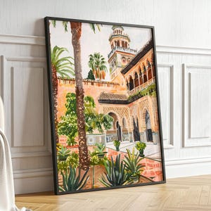 May include: Watercolour painting of a courtyard with a tower and palm trees. The artwork features a warm colour palette with shades of orange, green, and brown. The framed art piece is leaning against a white wall and wooden floor.
