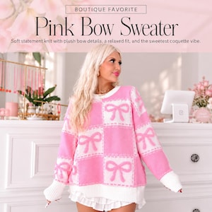 May include: A long-sleeved sweater featuring a pink and white checkered pattern with pink bow motifs in each square. The garment has a crew neckline, white ribbed cuffs, and a white ribbed hem. Text at the top reads: BOUTIQUE FAVORITE Pink Bow Sweater.