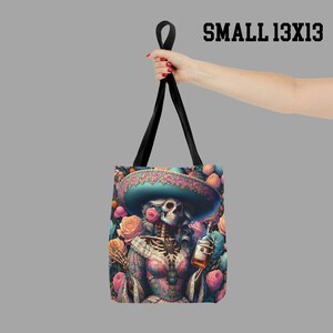 May include: A black tote bag with a colorful design featuring a skeleton wearing a sombrero and holding a bottle of liquor. The bag has a floral pattern and the text "SMALL 13X13" is printed in the top right corner.