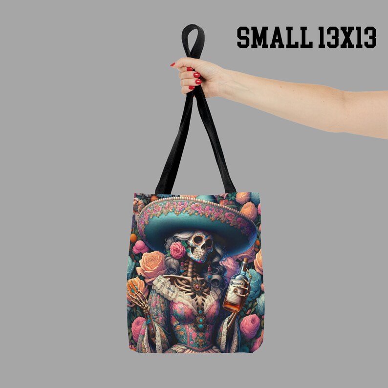 May include: A black tote bag with a colorful design featuring a skeleton wearing a sombrero and holding a bottle of liquor. The bag has a floral pattern and the text "SMALL 13X13" is printed in the top right corner.