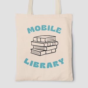 Peut inclure: Un sac fourre-tout en toile beige avec du texte bleu qui dit "MOBILE LIBRARY" et une illustration en noir et blanc d'une pile de livres.
