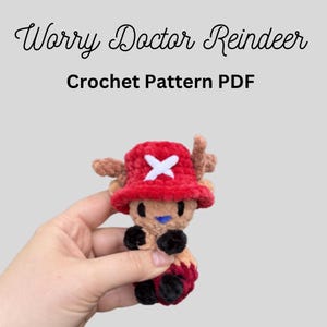 May include: A handmade crochet Worry Doctor Reindeer plushie, with a red hat and white cross, brown antlers, and black feet. The text "Worry Doctor Reindeer Crochet Pattern PDF" is displayed above the plushie.