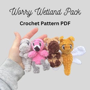 May include: The image displays four crocheted amigurumi creatures in a hand. The creatures are a gray reptile, a pink flamingo, a brown horse, and a yellow insect with white wings. The text "Worry Wetland Pack" and "Crochet Pattern PDF" are at the top.