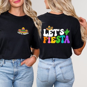 May include: Black t-shirt with "Let's Fiesta" text in rainbow colors and a cactus graphic on the back. The front of the shirt has a small sombrero graphic with "Let's Fiesta" text.
