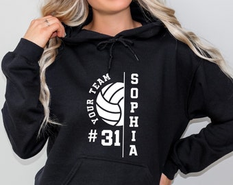 Może przedstawiać: Czarna bluza z kapturem z białym nadrukiem piłki siatkowej, tekstem "YOUR TEAM #31" i imieniem "SOPHIA" pionowo po prawej stronie.
