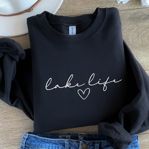 K&ouml;nnte beinhalten: Schwarzer Pullover mit wei&szlig;em Text, der "lake life" mit einem Herzsymbol sagt.