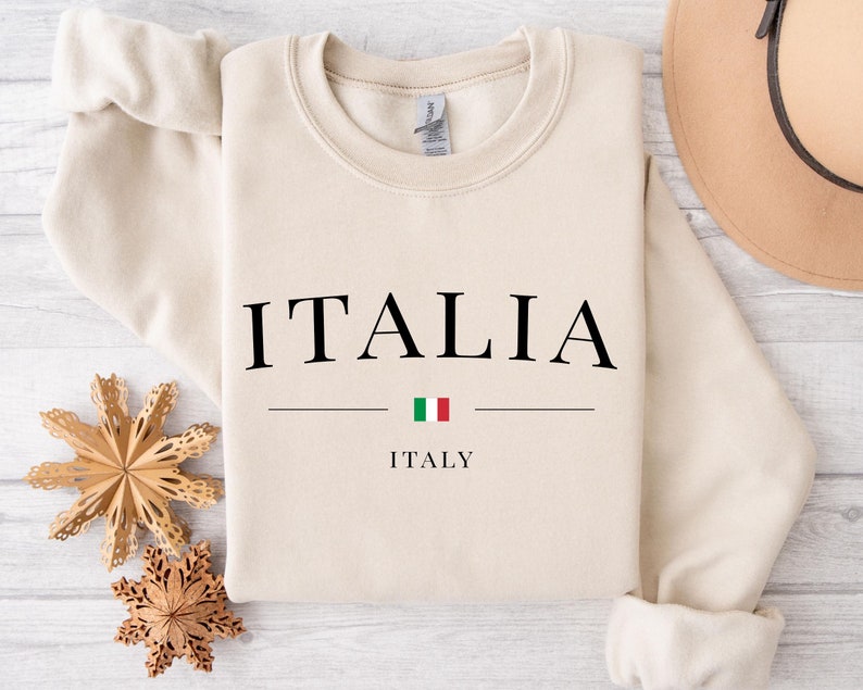 May include: A beige sweatshirt with the word "ITALIA" printed in black, with the Italian flag and the word "ITALY" underneath.
