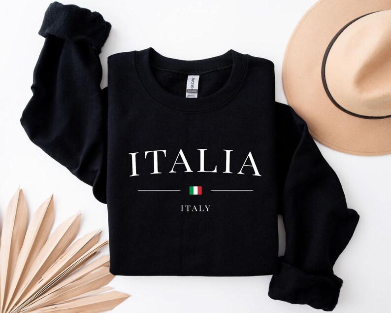 May include: Black sweatshirt with the word "ITALIA" in white text and the Italian flag underneath. The text "ITALY" is written in white below the flag.