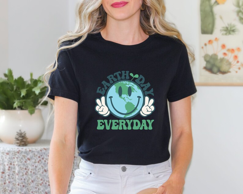 May include: Black t-shirt with a green and blue graphic of a smiling Earth with peace signs. The text "Earth Day Everyday" is printed below the graphic.