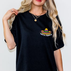 May include: Black t-shirt with a colorful graphic of a sombrero and the text "Let's Fiesta".