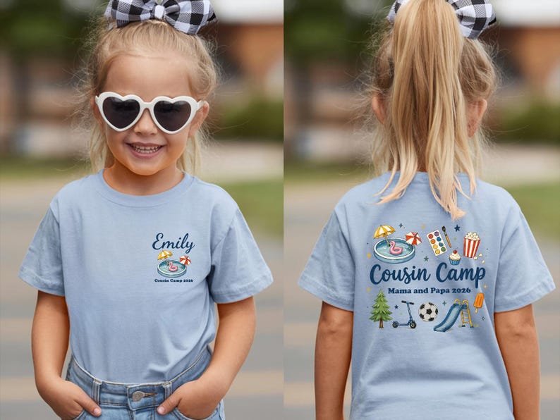 Pu&ograve; includere: Una t-shirt azzurra con una piccola grafica sul petto sinistro con il nome Emily e il testo Cousin Camp 2026. Il retro mostra una grafica pi&ugrave; grande con il testo Cousin Camp Mama and Papa 2026 e varie icone colorate.