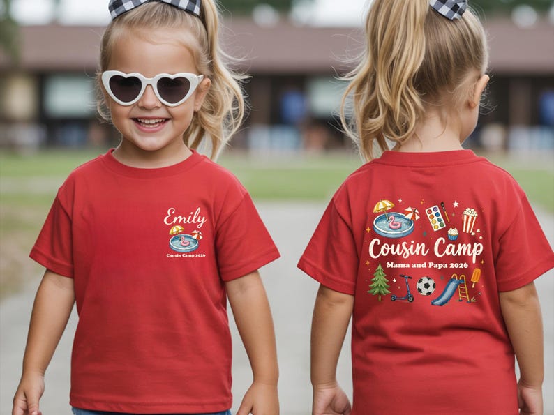 Pu&ograve; includere: Una t-shirt rossa a maniche corte con una piccola grafica sul petto che mostra una piscina, un ombrellone e il nome Emily sopra la scritta Cousin Camp 2026. Il retro presenta una grafica pi&ugrave; grande con la scritta Cousin Camp Mama and Papa 2026.