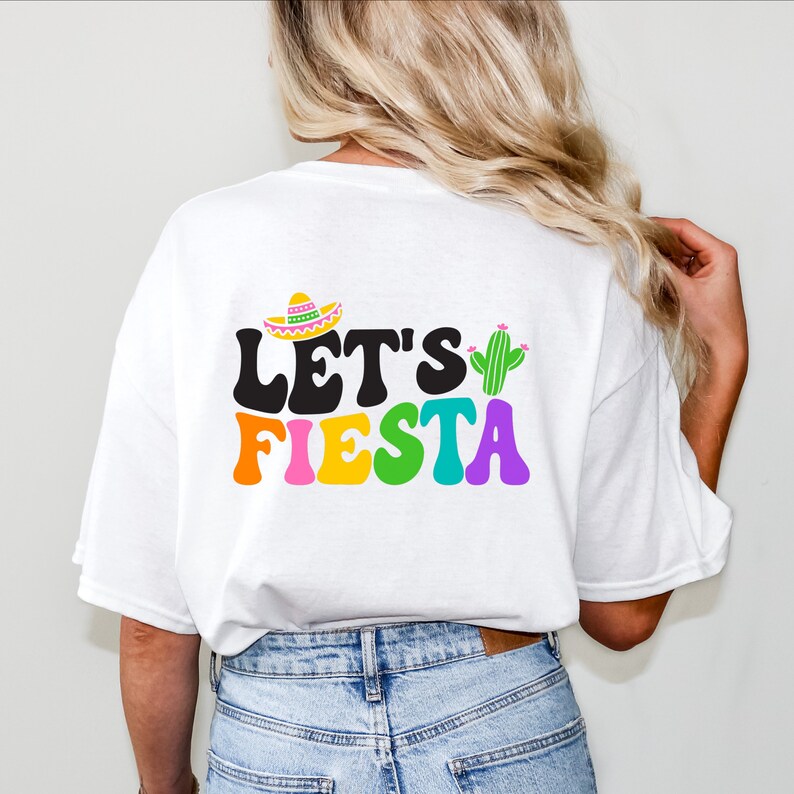 May include: White t-shirt with a colorful "Let's Fiesta" graphic featuring a sombrero and a cactus.