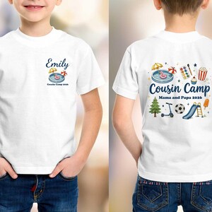 Pu&ograve; includere: Una t-shirt bianca con una piccola grafica sul petto con il nome Emily e il testo Cousin Camp 2026. Il retro mostra una grande illustrazione colorata di attivit&agrave; estive, il testo Cousin Camp e Mama and Papa 2026.
