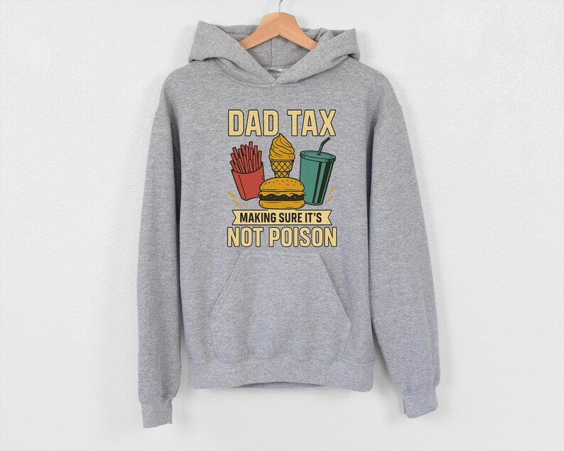 May include: A grey hoodie with a front pocket and a drawstring hood. The front features the text "DAD TAX" above a graphic of fries, ice cream, a burger, and a drink, with the text "MAKING SURE IT'S NOT POISON" below.