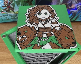 May include: Green card storage box with a cartoon illustration of a female warrior riding two brown bears. The warrior has brown hair and is wearing white and green clothing. The bears have green eyes and are snarling. The box is open, revealing the cards inside.