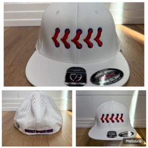May include: A white baseball cap with a curved peak. The cap has a series of red and blue arrow designs embroidered on the front. The cap has a structured fit and includes brand labels.
