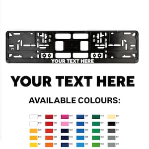 Puede incluir: Marco negro para matrícula con el texto "YOUR TEXT HERE" y una carta de colores. El marco tiene recortes para el montaje. La carta de colores muestra una gama de colores.