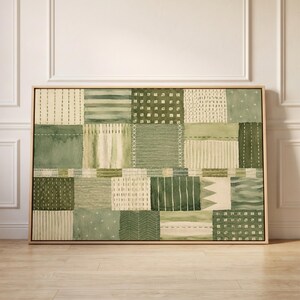 Peut inclure: Une œuvre d'art murale rectangulaire présentant un motif en patchwork composé de divers carrés verts et crème. Les motifs incluent des rayures, des points, des croisillons, des chevrons et des blocs unis, le tout dans un cadre en bois clair.