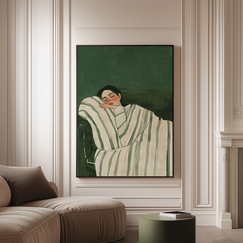 May include: An art print featuring a person resting on a sofa, draped in a striped blanket. The artwork has a dark green background and a black frame. The person's skin tone is light, and the blanket has green and white stripes.