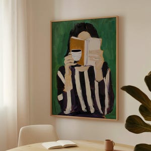 May include: An abstract painting depicts a person reading a book and holding a coffee cup. The figure wears a black and white striped shirt. The background is green, and the painting is in a wooden frame.