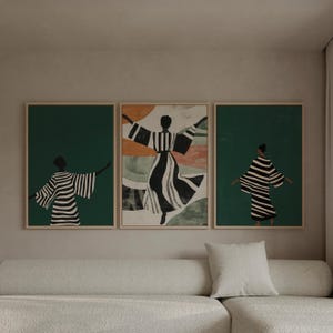 Op de afbeelding: Drie ingelijste kunstdrukken met abstracte figuren in vloeiende gestreepte kleding. Het kunstwerk heeft een minimalistische stijl met een kleurenpalet van zwart, wit, groen en oranje. De prints worden boven een crèmekleurige bank weergegeven.