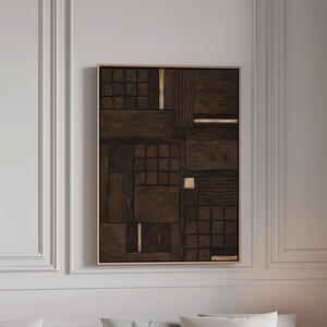 Op de afbeelding: Een rechthoekig wandkunstwerk bestaande uit een donkerbruine houten compositie met gevarieerde geometrische texturen, waaronder rasterpatronen, verticale latten en gladde panelen, geaccentueerd door dunne, verticale goudkleurige metalen strips.