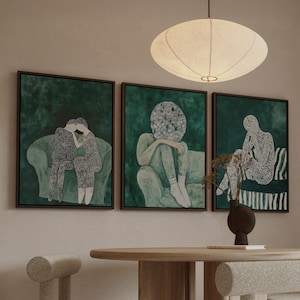Op de afbeelding: Drie ingelijste abstracte kunstwerken met donkergroene achtergronden. De kunst toont figuren in verschillende poses, waaronder een omhelzend stel en een persoon die op een bank zit. De frames zijn donkerbruin.