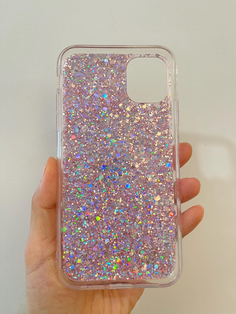Pu&ograve; includere: Una custodia per telefono trasparente con un design di glitter rosa e iridescente.