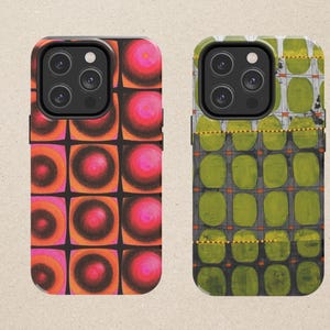 May include: Two smartphone cases featuring distinct patterns. The left case displays a grid of orange and pink circular gradients on a black background. The right case shows a grid of olive green rounded rectangles with thin orange lines.