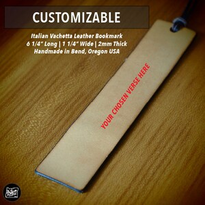 May include: A light brown leather bookmark with a black leather strap. The bookmark is 6 1/4 inches long, 1 1/4 inches wide, and 2 millimeters thick. The text "YOUR CHOSEN VERSE HERE" is printed in red on the bookmark.