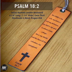 May include: An orange Italian Vachetta leather bookmark with the text "PSALM 18:2" and a cross. The bookmark is 6 1/4 inches long, 1 1/4 inches wide, and 2mm thick. The text of Psalm 18:2 is printed on the bookmark.