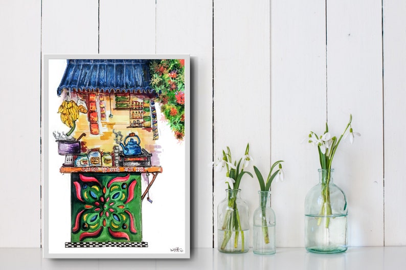 May include: Watercolor painting of a vibrant tea stall with a blue roof and green and red accents. A blue teapot steams on a small stove. The stall is decorated with colorful patterns and surrounded by flowers. The painting is framed and displayed with vases of white flowers.