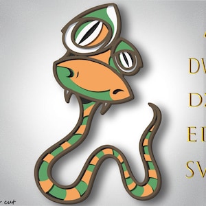 Puede incluir: Ilustración de una serpiente de dibujos animados con una combinación de colores verde, naranja y marrón. La serpiente tiene ojos grandes y expresivos y un cuerpo curvado. La imagen incluye texto que indica formatos de archivo: AI, DWG, DXF, EPS y SVG.