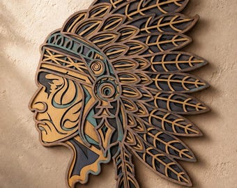 May include: A multi-layered wooden wall art piece depicting the profile of a person wearing a large, elaborate feathered headdress. The design features intricate cutouts in shades of dark brown, light tan, and muted teal, creating depth.