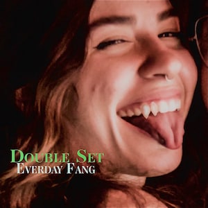 May include: A close-up of a person's mouth with fangs, smiling and sticking their tongue out. The text "DOUBLE SET EVERYDAY FANG" is written below the image.