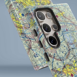 May include: A phone case featuring a detailed map design. The case is yellow, blue and brown with a black camera cutout. The map includes lines, numbers and letters.