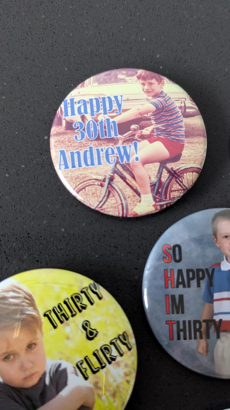 May include: Three round buttons with photos and text. The first button has a photo of a young boy on a bicycle with the text "Happy 30th Andrew!" The second button has a photo of a young boy with the text "Thirty & flirty". The third button has a photo of a young boy with the text "So Happy Im Thirty".